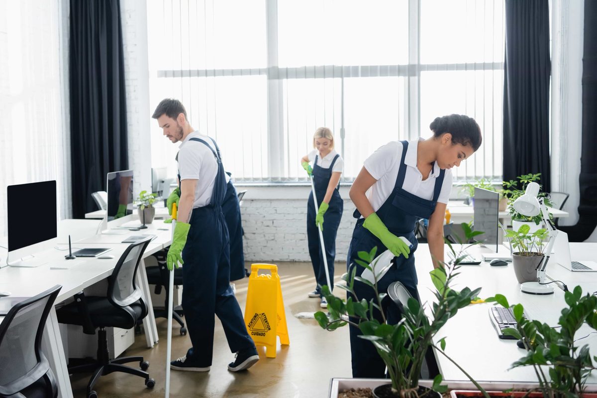 Cleaning team wiping desks and mopping in an office: office cleaning services in Fairfax, VA