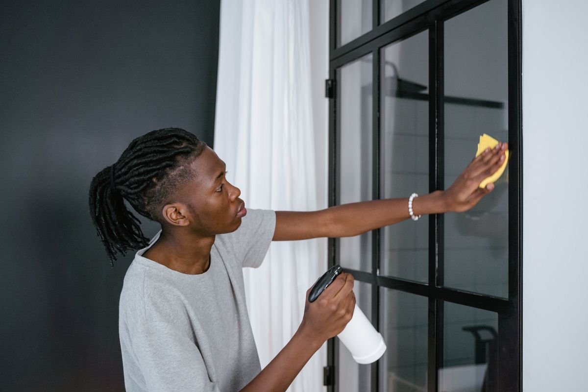 A cleaner wiping the glass panes of an interior door