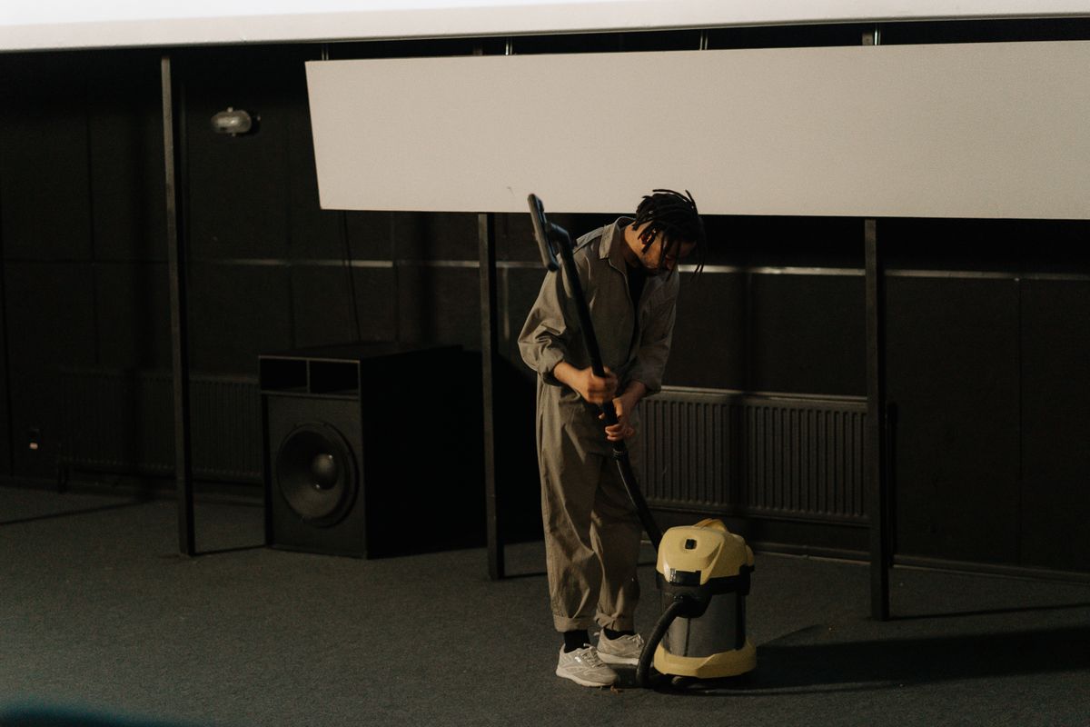 A cleaner vacuuming the floor of a large hall